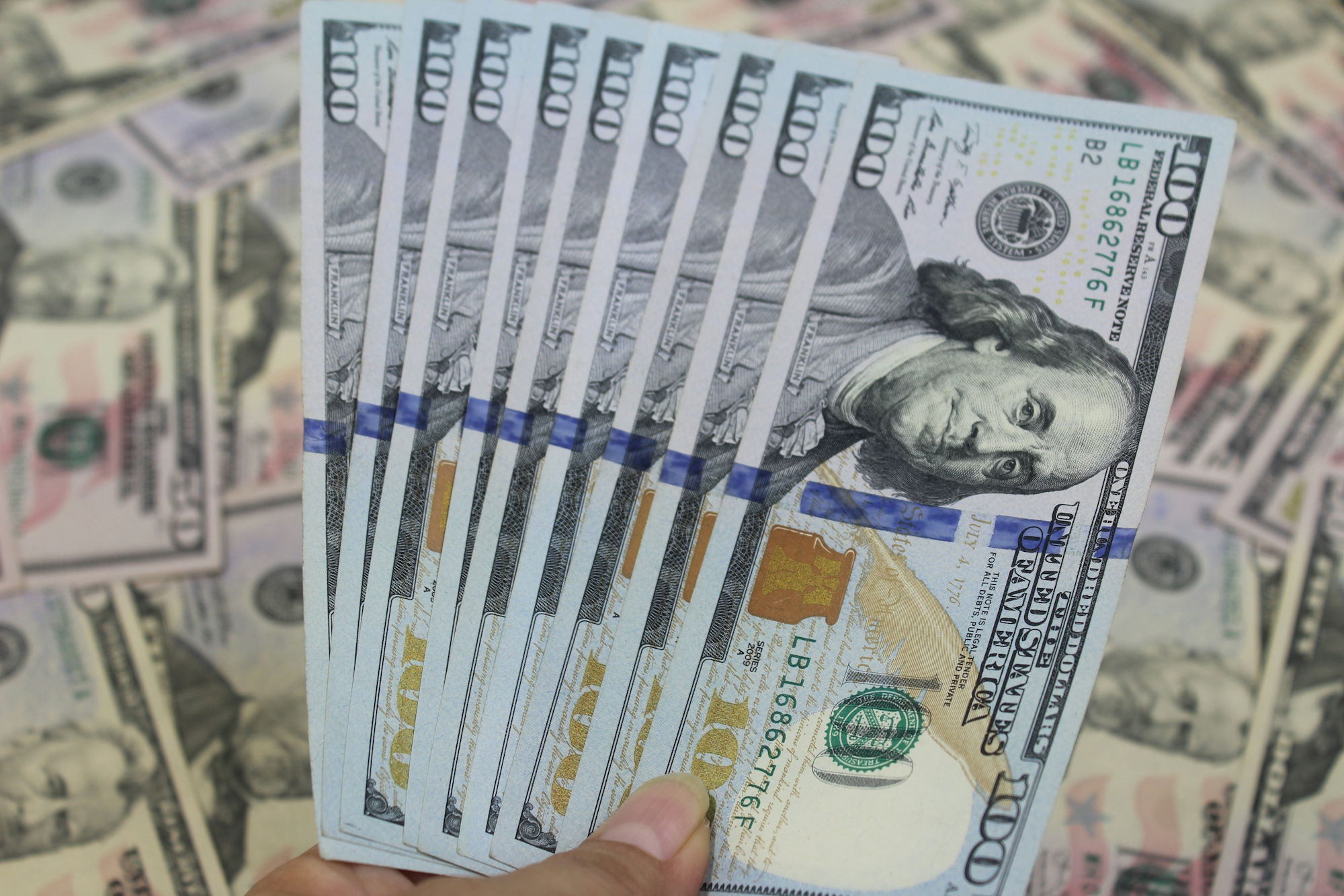 a-hand-holding-a-stack-of-paper-money.jpg a hand holding a stack of paper money